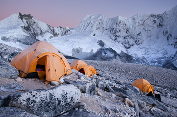 A group go yellow tents in the high snowy Himalaya at sunset - 288339796
