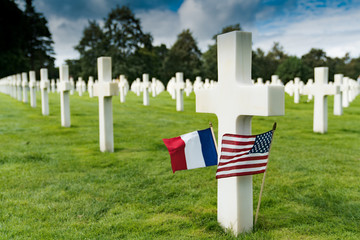 view of cross headstones in the American Cemetery at Omaha Beach in Normandy with French and US...