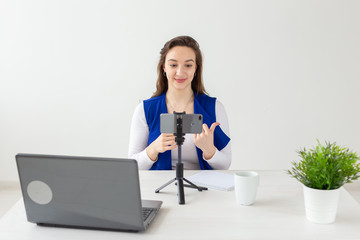 Blogging, broadcast and people concept - woman blogger is talking to the camera for her spectators