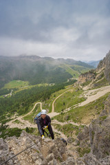 Fototapeta na wymiar attractive young female mountain climber on a Via Ferrata in the Dolomites