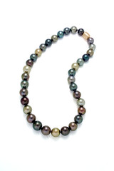 A necklace of a strand of multi colored tahition round pearls on a white background.