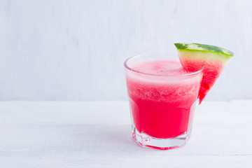 Watermelon drink in glasses with slices of watermelon. Watermelon smoothies on white background. Summer healthy drink for vegetarian. Copy space