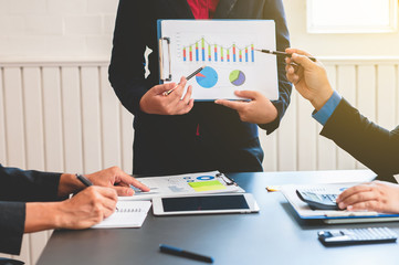 Business people discussing the charts and graphs showing the results of their successful teamwork.