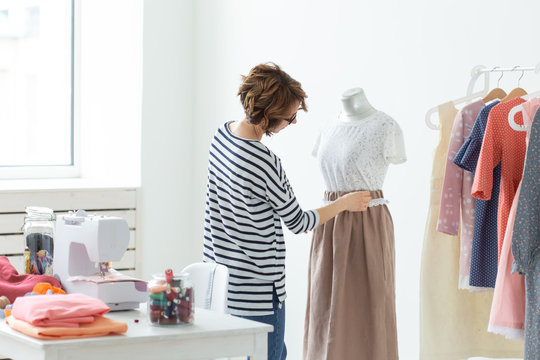 Fashion designer, seamstress and Small-Sized Enterprises concept - woman seamstress decorates a mannequin