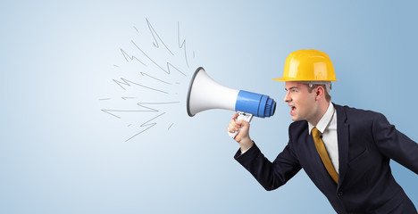 Fototapeta premium Young architect constructor yelling with megaphone and copyspace