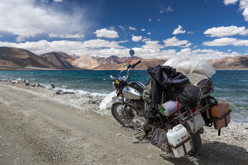 Traveling near Pangong Lake in Ladakh by vintage motorcycle. Off-road trail leading to highland lake with vintage motorcycle. © Eugene Ga