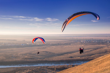 Paraglide with a paraglider in a cocoon against the background of fields of the sky and clouds....