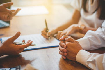 Salespeople are explaining the deal to customers to sign the contract.