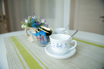 cup, sugar and tea bags for guests of an inexpensive resort room