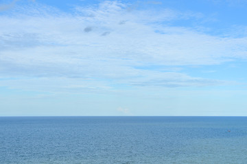 Fototapeta premium Deep blue sea and sky with white cloud on horizon as background.