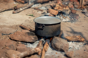 A large cast iron cooking pot on a fire in rural Mozambique, Africa