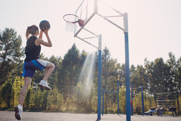 Young woman basketball player playing street ball