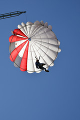 a man jumping with parachute