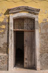 Fototapeta na wymiar A doorway in a weathered stone wall in the Island of Mozambique (Ilha de Mocambique) town. Nampula Province, Mozambique, Africa