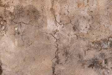 Background in the form of a gray stone plastered surface with many cracks of different shapes and sizes