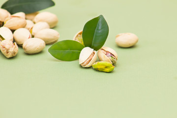 Several pistachios from close range with green leaves