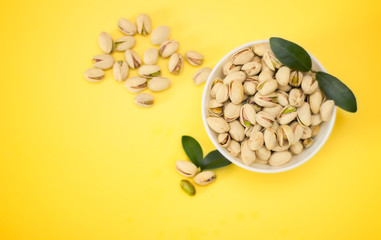 Nuts, pistachios from above on yellow background