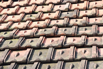 roof details .tile roofing and shake gable details on a new home and red background.