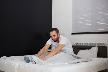 Man waking up in his bedroom and stretching.