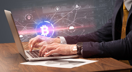 Hand checking on laptop global bitcoin exchange rate concept