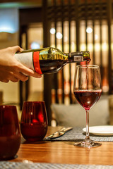 A Waiter Pouring Red Wine into a Wine Grass