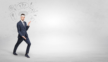 Obraz premium Young businessman in suit fighting with doodled symbols concept