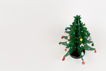 The toy wooden green Christmas tree with little toys on white background
