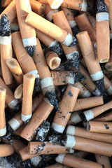 Dirty cigarette butts in a metal bowl