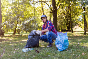 Young man picking up litter in his local park