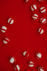 Peppermint candies on vivid red background from above. Winter, New Year, Christmas seasonal minimalism still life, flat lay. Copyspace for text. 