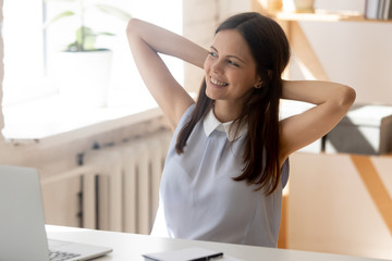 Smiling young female employee look in distance dreaming