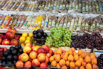 Venice, Italy, 4 August 2019: fruits apples, peaches, grapes, apricots and plums and spices on table counter for sale in street market