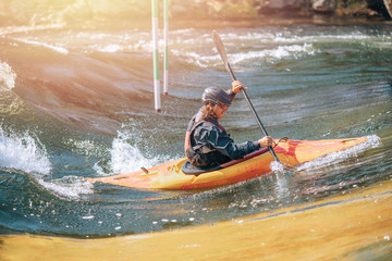 Fototapeta premium Guy in kayak sails mountain river. Whitewater kayaking, extreme sport rafting