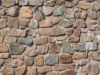 An old wall of different shaped stones. Background and texture.