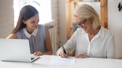 Smiling senior woman sign business contract in office