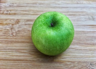 Ripe green apple whole piece on wooden background
