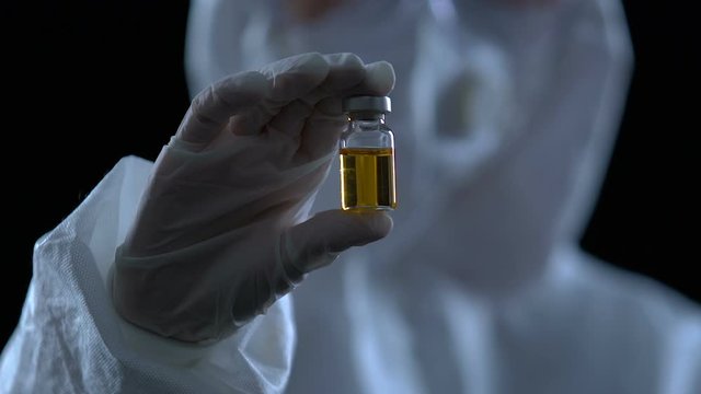 Researcher showing bottle with vaccine to camera, poison antidote development