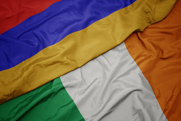waving colorful flag of ireland and national flag of armenia.