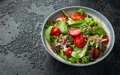 Buckwheat salad with cherry tomatoes, red onion and green vegetables. Healthy diet food