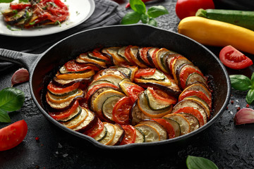 Ratatouille Vegetable Stew with zucchini, eggplants, tomatoes, garlic, onion and basil. on cast iron pan. Traditional French food.