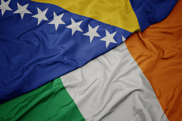 waving colorful flag of ireland and national flag of bosnia and herzegovina.