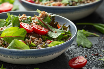 Buckwheat salad with cherry tomatoes, red onion and green vegetables. Healthy diet food