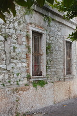 Fototapeta na wymiar Building made of gray stone and bars on the windows