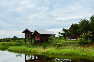 Fototapeta na wymiar Traditional Thai house. Thai style wooden house near river with shadow reflection in water