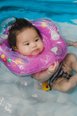 Fototapeta na wymiar Close up portrait Asian cute baby girl 4 month-old in kit inflatable pool