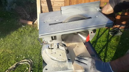 Detail of circular saw cutting a wooden board,