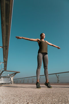 Sportswoman doing exercises on the bridge stock photo