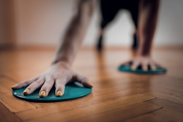 Female Athlete Exercising with Sliding Discs.
