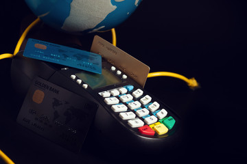 globe and lan wire with premium credit card of digital banking investment financial and money concept on black background, electronic payment device reader machine