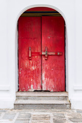 Red vintage wooden door made to plank peeling paint and large locked old wooden with padlock rusty.